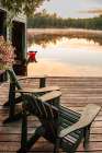 USA, New York. Adirondack Park, Saranac Lake, Hoel Pond, Adirondack chairs on boathouse dock. Art Print